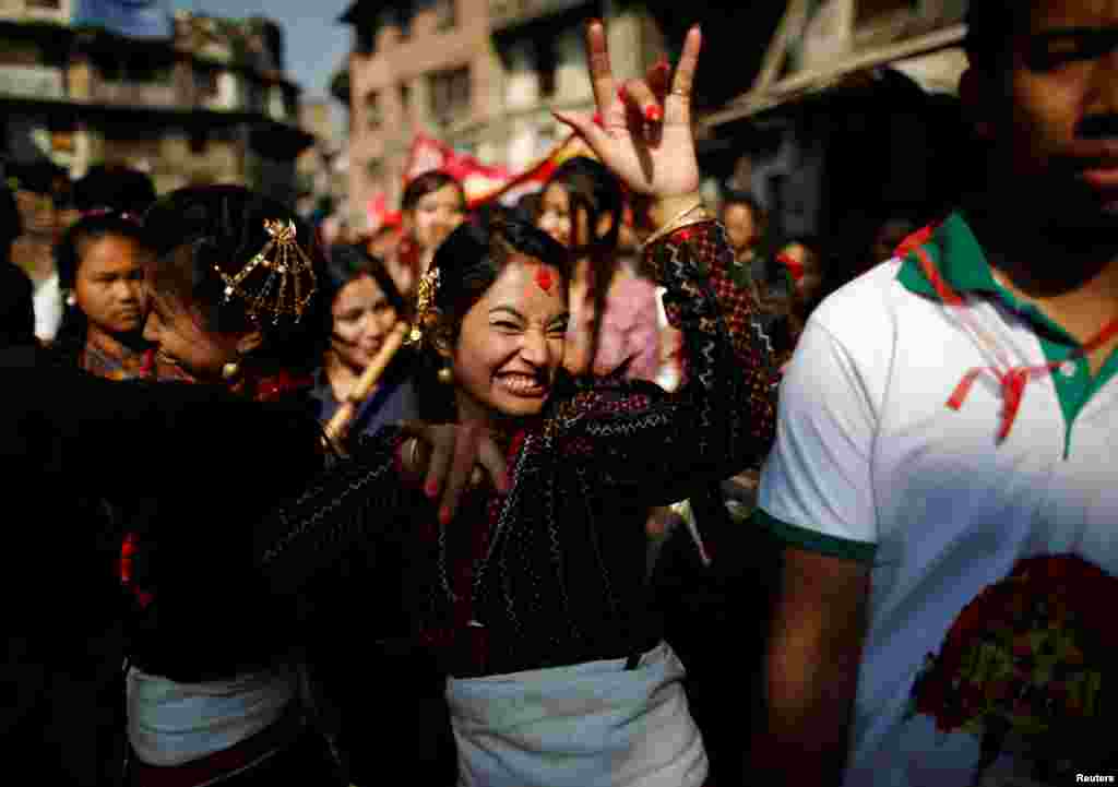 Warga dengan pakaian tradisional menari untuk memeriahkan parade dalam festival Diwali di Kathmandu, Nepal.