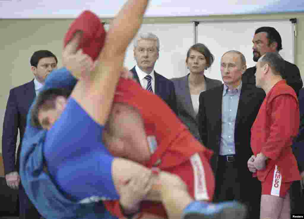Presiden Rusia Vladimir Putin dan aktor Steven Seagal (belakang paling kanan) mengunjungi arena olahraga baru di kompleks pelatihan olahraga di Moskow.