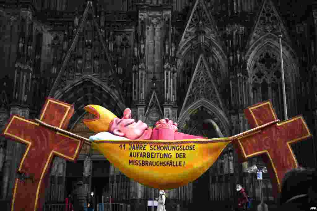 A sculpture by artist Jacques Tilly with the slogan '11 years of relentless investigation of the abuse cases!' is seen in front of the Cologne Cathedral in Cologne, Germany, as a long-awaited report was published on alleged sexual violence in Germany's to