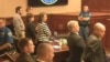 In this image made from Colorado Judicial Department video, Defendant James Holmes, top left in tan shirt, defense attorneys, top left, and prosecuting attorneys watch as the jury exits the courtroom after delivering their sentencing verdict in the Colora