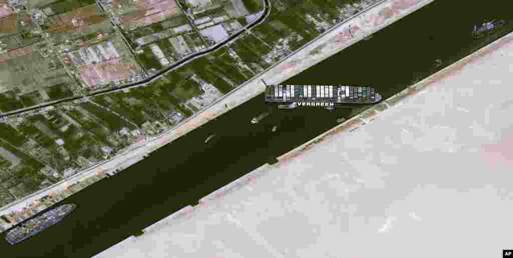 This satellite image from Cnes2021, Distribution Airbus DS, shows the cargo ship MV Ever Given stuck in the Suez Canal near Suez, Egypt. The skyscraper-sized cargo ship wedged across the Suez Canal further imperiled global shipping as at least 150 other vessels needing to pass through the crucial waterway idled, authorities said.