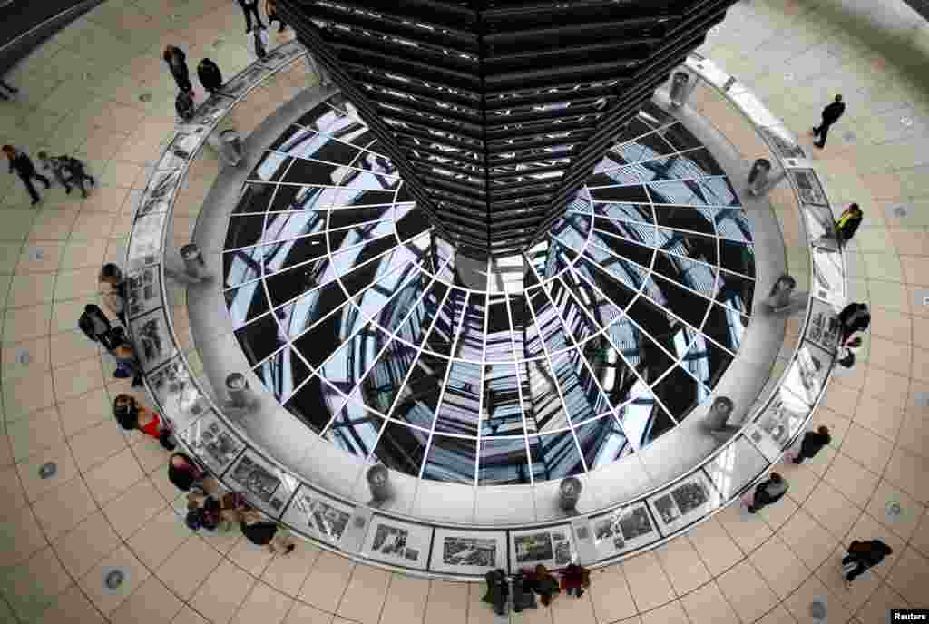 Orang-orang berjalan di dalam kubah gedung Reichstag, gedung majelis rendah parlemen Jerman di Berlin.