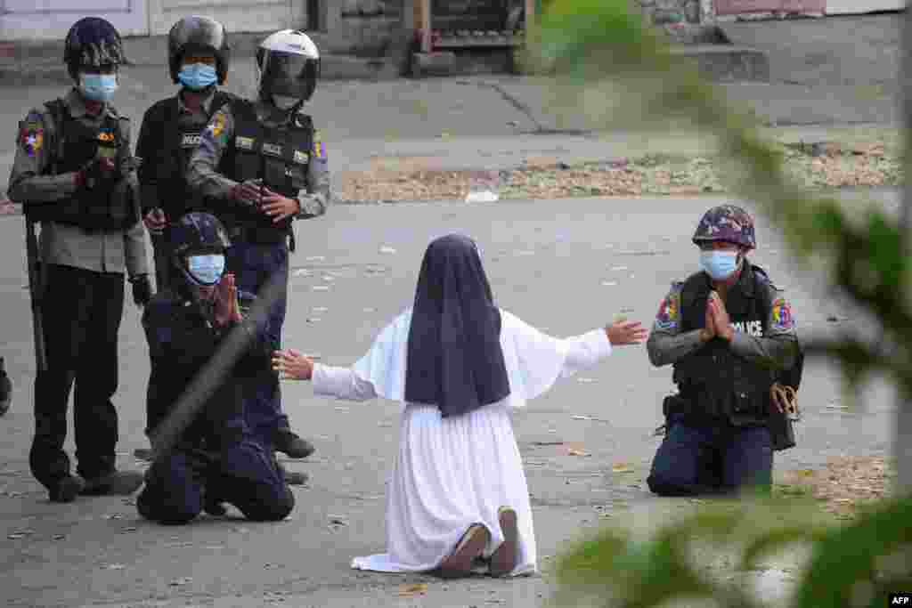 This handout photo by the Myitkyina News Journal shows a nun pleading police not to harm protesters in Myitkyina in Myanmar's Kachin state, March 8, 2021.