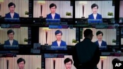 A man watches the television message that Hong Kong Chief Executive Carrie Lam makes an announcement on the extradition bill, at a home electronics retailer in Hong Kong, Sept. 4, 2019.