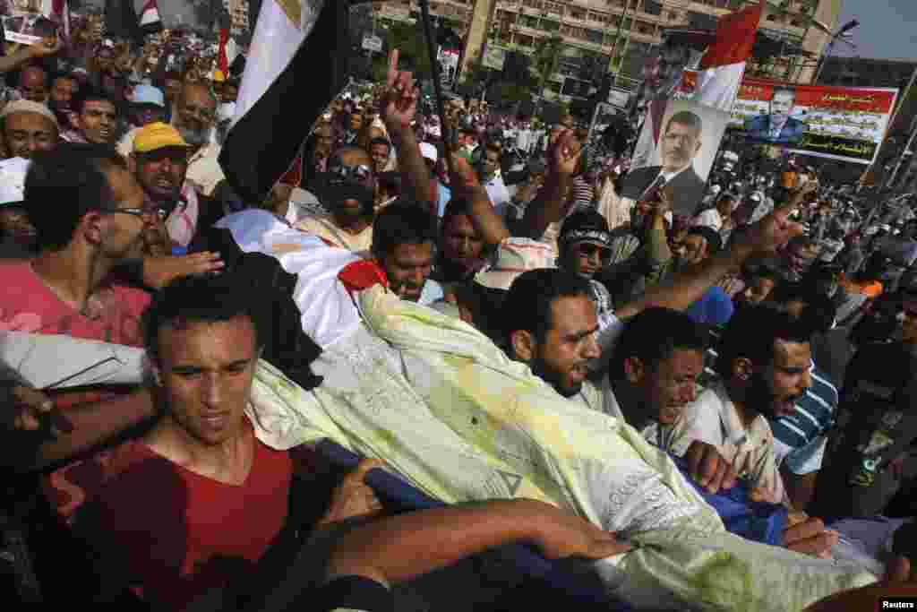 Người ủng hộ ông Morsi khiêng thi thể một người biểu tình thiệt mạng trong các vụ bạo động bên ngoài Trụ sở Vệ binh Cộng hòa tại Cairo, ngày 9/7/2013.