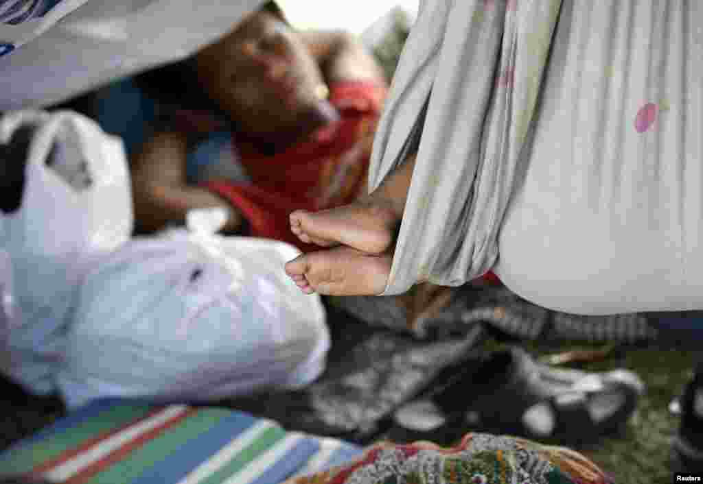 Para warga desa yang melarikan diri dari pertempuran antara pasukan pemerintah dan pasukan pemberontak Muslim, beristirahat di dalam tenda-tenda mereka di sepanjang jalan Zamboanga, Filipina (18/9). (AP/Bullit Marquez)