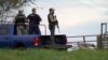 Agentes de policía sostienen rifles mientras investigan una escena, en Bowdoin, Maine, el 26 de octubre de 2023, durante la búsqueda del sospechoso de los tiroteos masivos mortales en Lewiston, Maine, el día anterior. 