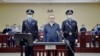 This handout photo taken on August 11, 2020 and released by the Second Intermediate People’s Court of Tianjin, shows Lai Xiaomin (C), former chairman of China Huarong Asset Management Co., standing during his trial at the Second Intermediate People…