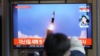 韩国民众在首尔一个火车站观看电视播放的朝鲜试射导弹新闻画面。（2022年1月27日）
