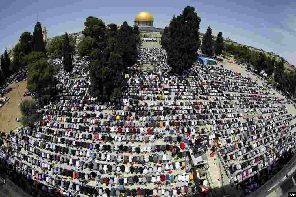 A picture taken with a fisheye lense shows Palestinian worshippers praying outside the Dome of the Rock in Jerusalem's Al-Aqsa Mosque compound, Islam's third holiest site, on the last Friday of the Muslim holy month of Ramadan.