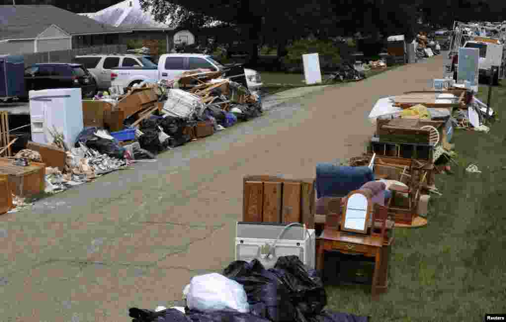 Tumpukan barang-barang yang rusak akibat banjir di pinggir jalan St. Amant, Louisiana (21/8). (Reuters/Jonathan Bachman)