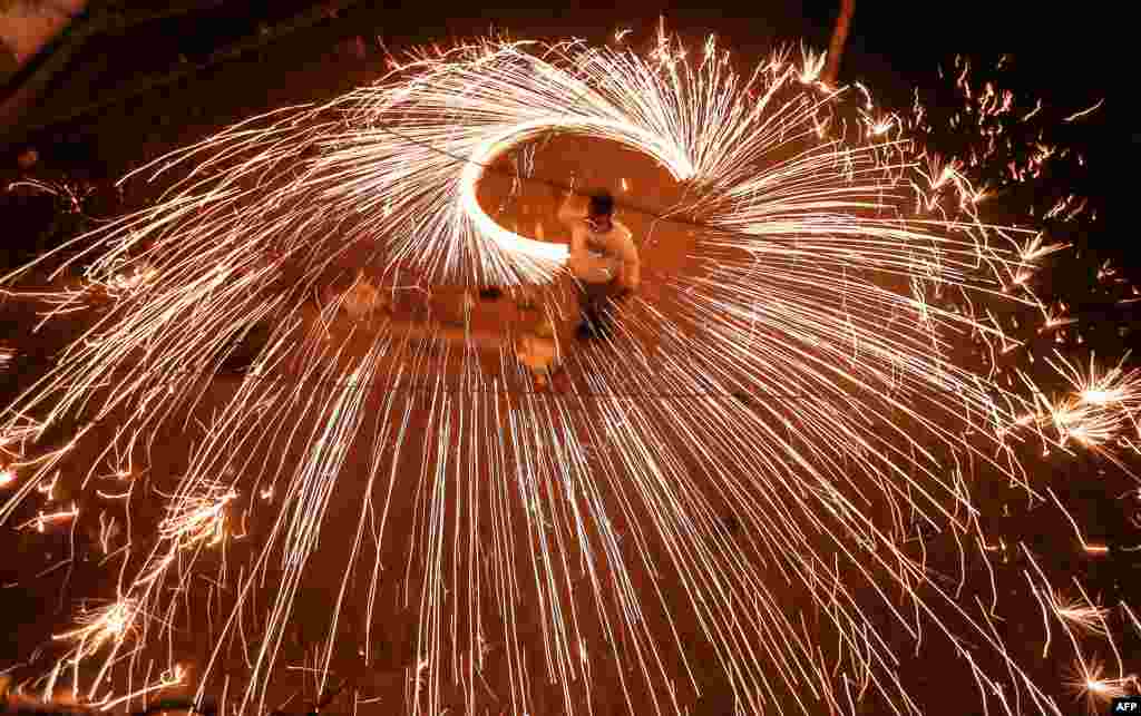 A Palestinian youth swings a homemade fireworks sparkler as people celebrate ahead of the Muslim holy fasting month of Ramadan, in Gaza City, on April 11, 2021.