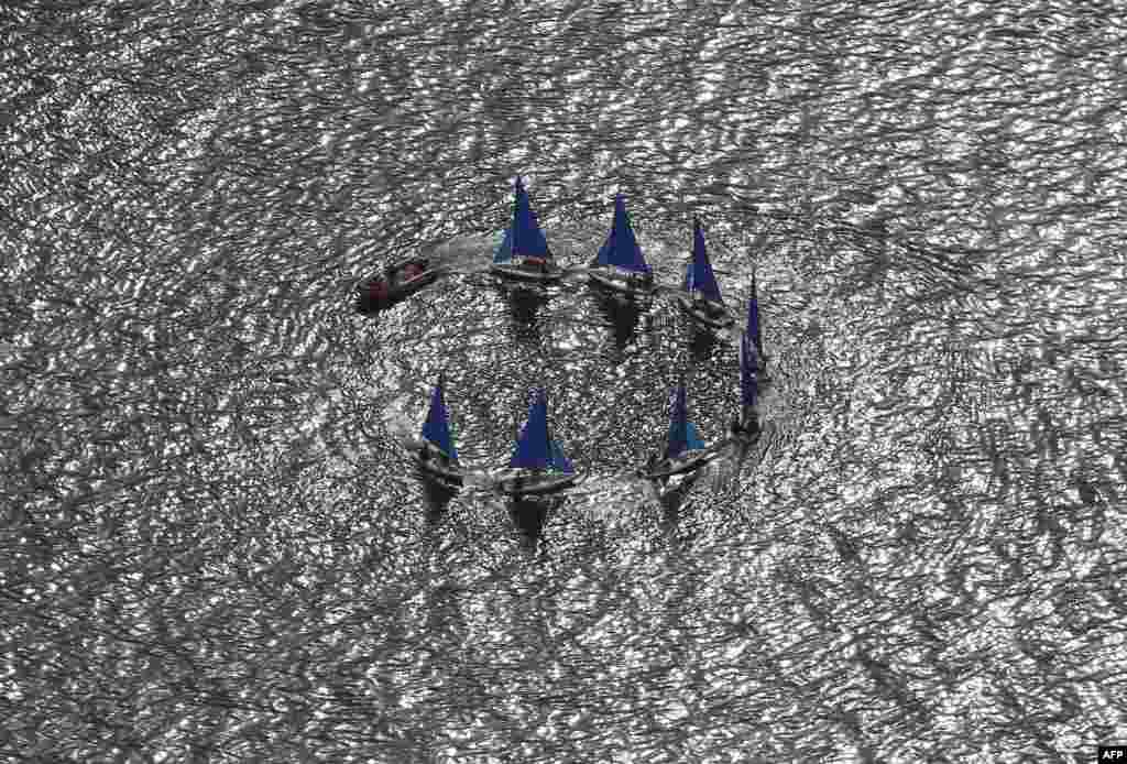 An aerial view of sailboats forming a circle in the ocean near Monaco.