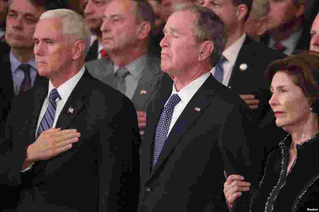 Makamu wa Rais Marekani, Mike Pence, Rais wa zamani wa Marekani, Geoge W.Bush, ,na Mkee wake Laura Bush, wakiangalia jeneza lenye mwili wa Rais wa Zamani wa Marekani Geouge H. W Bush ndani ya jengo la Capitol, Washington DC, Dec 3, 2018