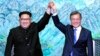 North Korean leader Kim Jong Un, left, and South Korean President Moon Jae-in raise their hands after signing a joint statement at the border village of Panmunjom in the Demilitarized Zone, South Korea, April 27, 2018.
