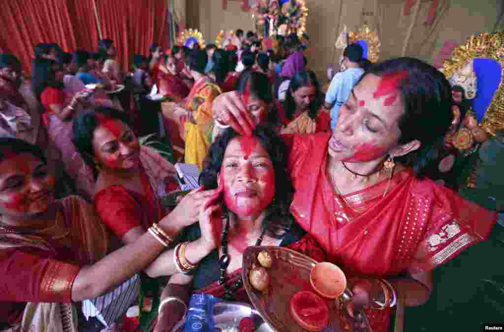 Hindu women apply 'Sindur', or vermillion powder, on the face of a woman on the last day of the Durga Puja festival in the northern Indian city of Chandigarh.