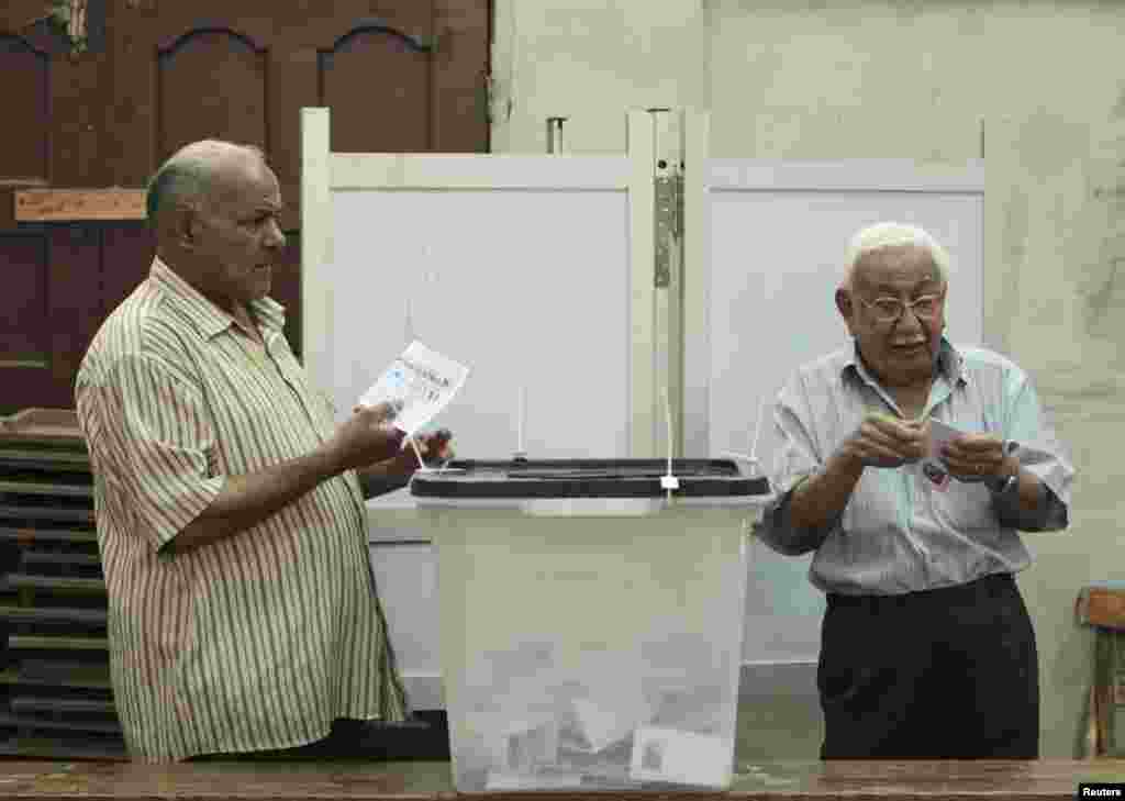 Men cast their vote at a polling station in Cairo May 23, 2012.