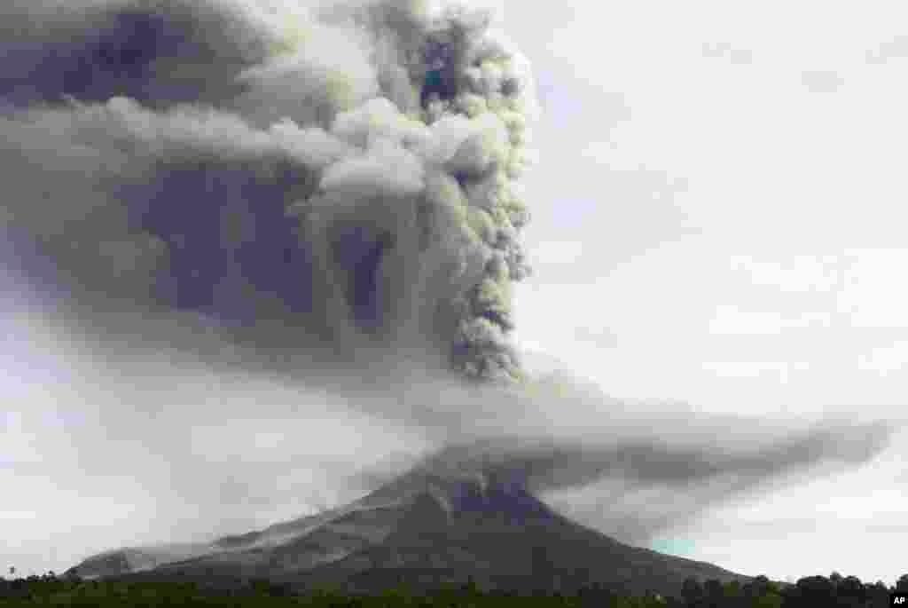 Mount Sinabung spews volcanic material as it erupts as seen from Tiga Pancur, North Sumatra, Indonesia, Nov. 18, 2013.