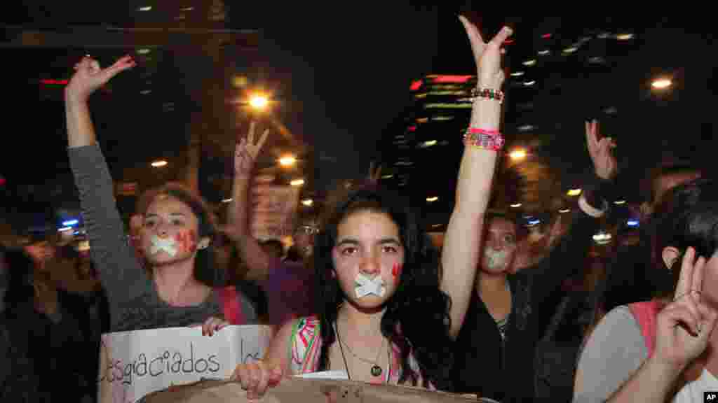 Para demonstran berbaris di jalanan Mexico City, memprotes pemerintah atas hilangnya 43 mahasiswa di negara bagian Guerrero (5/11). (AP/Marco Ugarte)